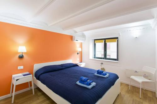 1 dormitorio con 1 cama con 2 toallas azules en Home Maletto, en Palermo