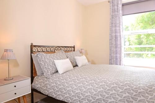 a bedroom with a large bed with a window at Jevington Gardens in Eastbourne