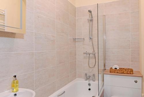 uma casa de banho com um chuveiro, uma banheira e um lavatório. em Jevington Gardens em Eastbourne