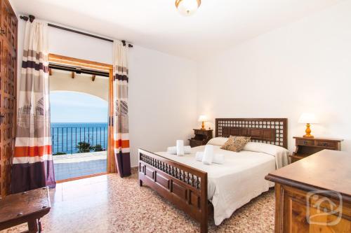 a bedroom with a bed and a view of the ocean at Villa Bellavista by Abahana Villas in Benissa