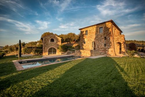 an old stone building with a swimming pool in a yard at La Cotogna in Magione
