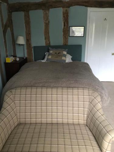 a bedroom with a large bed with a tiled floor at Waldegrave farm in Hartest