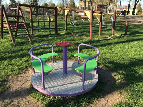 two chairs and a table on a playground at Borowiak in Szteklin