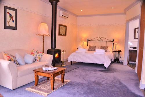 ein Wohnzimmer mit einem Bett und einem Kamin in der Unterkunft Bindley House B&B Cottage in Kilmore