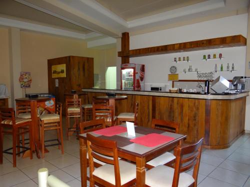 a restaurant with a table and chairs and a bar at Água Viva Hotel in Olímpia