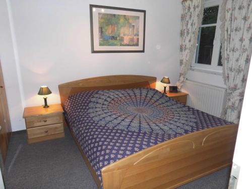 een slaapkamer met een houten bed en 2 nachtkastjes bij 54 Appartement Residenz Bellevue U in Zinnowitz
