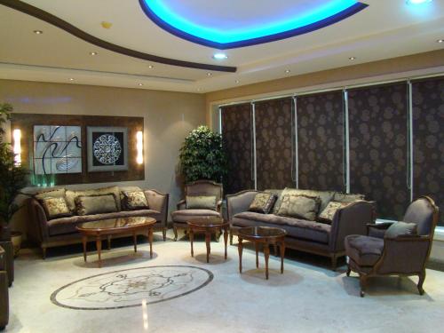 a living room with couches and tables and a blue light at Manazilna Apartments Riyadh منازلنا للشقق المفروشة in Riyadh