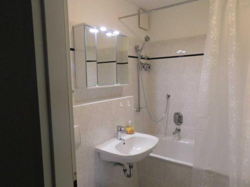 Un baño blanco con lavabo y ducha. en Appartement 53 Residenz Bellevue Used, en Zinnowitz
