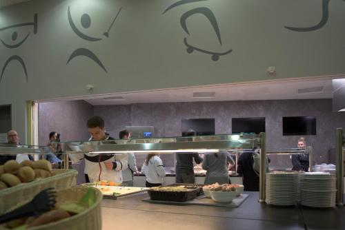 un grupo de personas en una cocina preparando comida en Landessportschule Bad Blankenburg, en Bad Blankenburg