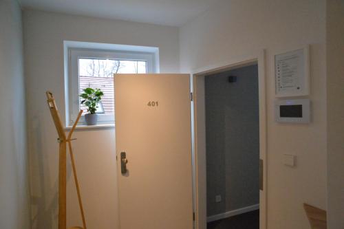 um frigorífico branco num quarto com uma janela em Grey House Apartments Grossbeeren em Großbeeren