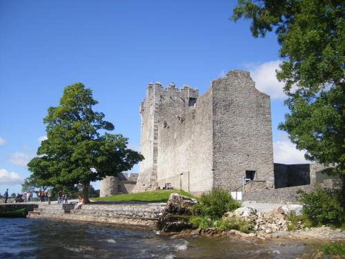 a castle sitting next to a body of water at Ros Villa Guesthouse in Killarney