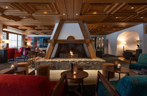 a lobby with a fireplace and tables and chairs at Sunstar Hotel & SPA Grindelwald in Grindelwald