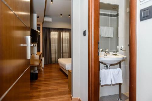 a bathroom with a sink, toilet and a mirror at Agamemnon Hotel in Nafplio