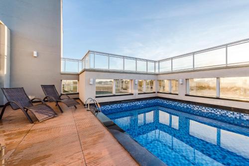 uma piscina numa casa com um edifício em Serata Hotel em Fernandópolis