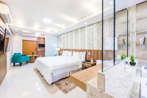 a hotel room with a bed and a glass wall at Serata Hotel in Fernandópolis