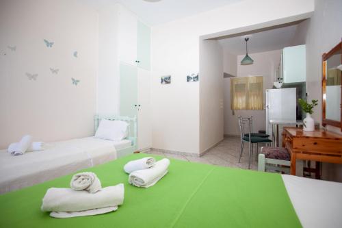 a hotel room with two towels on a green table at Eliza Apartments in Rethymno Town
