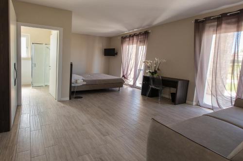 a bedroom with a bed and a desk and windows at Residenza Angelica in Lazise