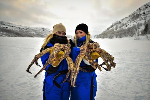 two women standing in the snow holding aarantula at Snowhotel Kirkenes in Kirkenes