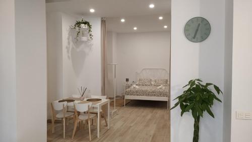 jadalnia ze stołem i zegarem na ścianie w obiekcie Suites Jeronimo de Cordoba w Sewilli