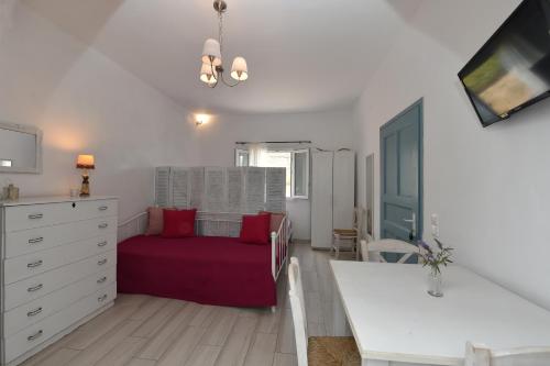 a bedroom with a bed and a table in a room at ''Sea front'' Rose's house in Kardiani