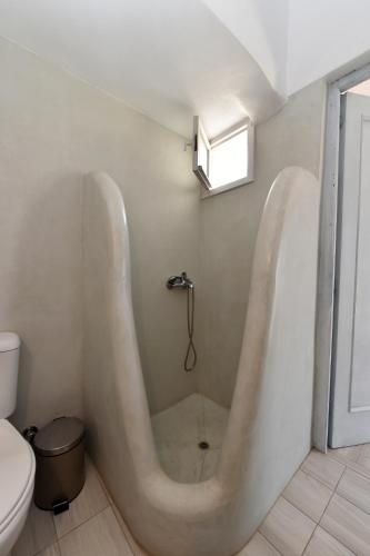 a bath tub in a bathroom with a toilet at ''Sea front'' Rose's house in Kardiani