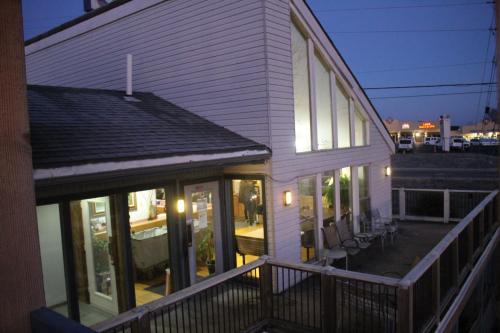 ein weißes Haus mit Fenstern und einer Terrasse mit Stühlen in der Unterkunft Hawk's Nest Lodge in Osage Beach