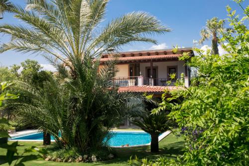 eine Villa mit einem Pool und Palmen in der Unterkunft Villa Mertcan by Important Group Travel in Yalıkavak