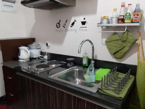 a kitchen counter with a sink and a stove at A Cozy fully furnished PRIVATE ROOM IN CONDOMINIUM unit. in Cebu City