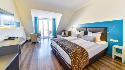 a hotel room with a large bed and a desk at Hotel Volapük in Konstanz