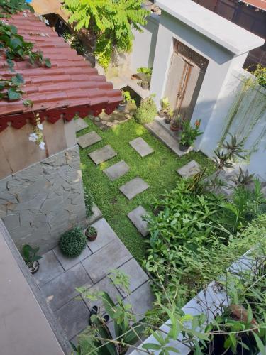 a garden with stepping stones in front of a house at Nextdoor Rooms in Yogyakarta