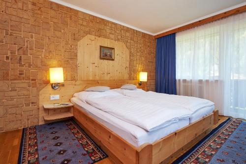 ein Schlafzimmer mit einem großen Bett in einer Ziegelwand in der Unterkunft APART Landhaus Gstrein in Oetz