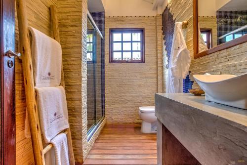 a bathroom with a tub and a sink and a toilet at A Casa de Gabriella in Itacaré
