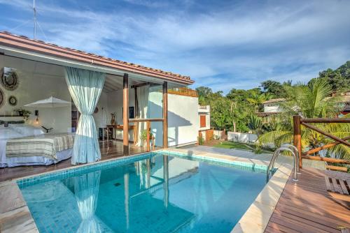 a bedroom and a swimming pool in a villa at A Casa de Gabriella in Itacaré
