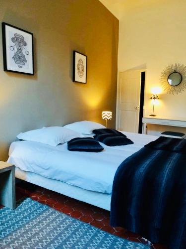 - une chambre avec 2 grands lits blancs et des oreillers noirs dans l'établissement Appartement coeur historique Aix, à Aix-en-Provence