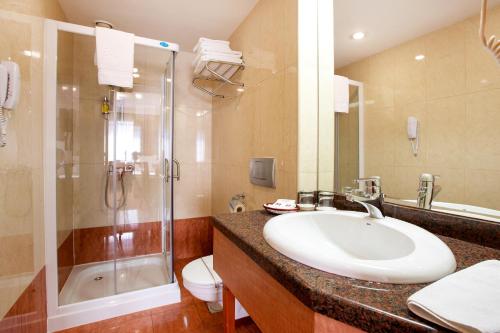 
a bathroom with a tub, sink, and shower at Hotel Duke Romana in Bucharest
