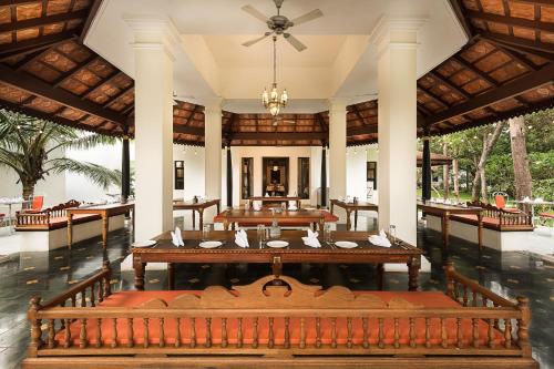 a large dining room with tables and a ceiling at Mantra Koodam Kumbakonam - A CGH Earth Experience in Kumbakonam