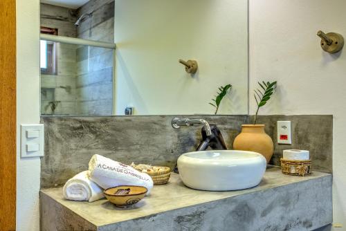 a bathroom counter with a sink and a mirror at A Casa de Gabriella in Itacaré