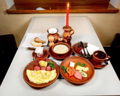 a table with plates of food and a candle at GORHouse Hotel in Yaremche