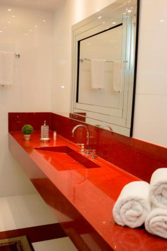 a bathroom with a red sink and a mirror at Hotel Cravo e Canela in Campos dos Goytacazes