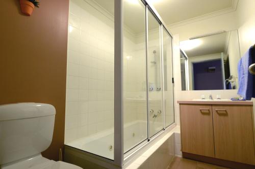 a bathroom with a shower and a toilet and a sink at Falls Creek Country Club in Falls Creek