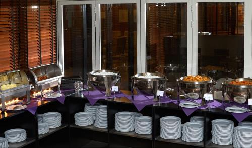 a table with white plates and silver dishes on it at Imperial Hotel in Copenhagen