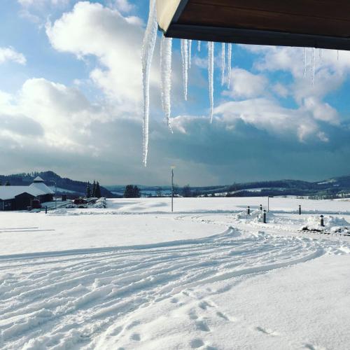 a snow covered field with icicles hanging from a car at Grund Resort Golf and Ski in Mladé Buky