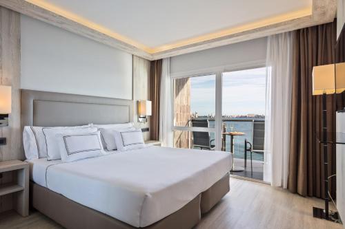 - une chambre avec un grand lit blanc et un balcon dans l'établissement Melia Alicante, à Alicante