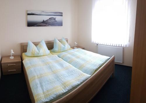 een slaapkamer met twee bedden en een raam bij Hausnordlicht FEWO 1 in Dornum