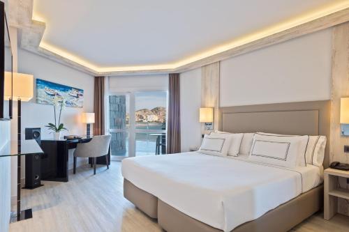 a bedroom with a large white bed and a desk at Melia Alicante in Alicante