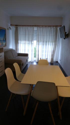 een woonkamer met een tafel en stoelen en een bank bij Mar Del Plata Playa Grande in Mar del Plata