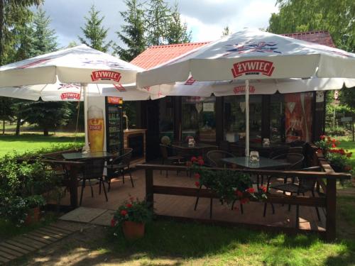 a restaurant with tables and chairs under umbrellas at Borowiak in Szteklin