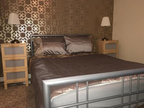 ein Schlafzimmer mit einem Bett und zwei Nachttischen in der Unterkunft Causeway Holiday Homes in Coleraine