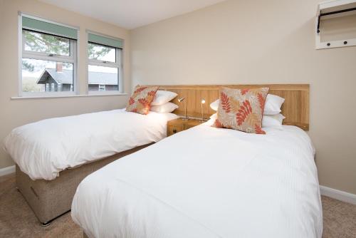 two beds in a room with two windows at Brown Rigg Guest Rooms in Bellingham