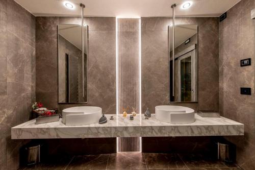 a bathroom with two sinks and two mirrors at Hotel Le Ortensie in Roccaraso